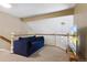 Loft area featuring a cozy blue couch, railing overlooking downstairs, and entertainment center at 12 Long Spur, Littleton, CO 80127