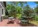 Charming patio with seating area surrounded by lush greenery and shade trees, perfect for outdoor relaxation at 12 Long Spur, Littleton, CO 80127