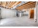 Unfinished basement with concrete floor, open ceiling with exposed beams and access to stairs at 1640 Winona Ct, Denver, CO 80204