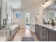 Contemporary bathroom boasting a glass-enclosed shower, soaking tub, double vanity and wood-look tile flooring at 1640 Winona Ct, Denver, CO 80204