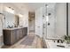 Modern bathroom with double vanity, walk-in shower, and wood-look tile flooring, plus access to the walk-in closet at 1640 Winona Ct, Denver, CO 80204