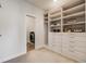 Well-organized walk-in closet with built-in shelving and drawers, plus access to the laundry area at 1640 Winona Ct, Denver, CO 80204