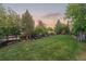 Expansive backyard featuring a lush lawn, mature trees, and a cozy seating area with well-manicured garden at 16815 E Prairie Goat Ave, Parker, CO 80134