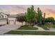 Charming single Gathering home boasts a lush, green lawn, mature trees, and a welcoming entrance with a stone facade at 16815 E Prairie Goat Ave, Parker, CO 80134