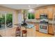 Modern kitchen featuring a granite island, stainless steel appliances, hardwood floors, and outdoor access at 16815 E Prairie Goat Ave, Parker, CO 80134