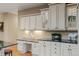 Bright kitchen featuring granite countertops, white cabinetry, and glass display cabinets at 16815 E Prairie Goat Ave, Parker, CO 80134