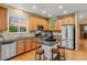 Open kitchen with an island, granite counters, stainless steel appliances, seating, and wood floors at 16815 E Prairie Goat Ave, Parker, CO 80134