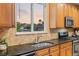 Well-lit kitchen featuring granite countertops, stainless steel appliances, and a window with a neighborhood view at 16815 E Prairie Goat Ave, Parker, CO 80134