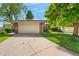 Well-maintained home featuring a spacious garage and beautifully landscaped lawn at 7427 W Cedar Cir, Lakewood, CO 80226