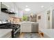 Bright kitchen features stainless steel appliances, white cabinets, and a large window at 7427 W Cedar Cir, Lakewood, CO 80226