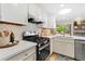 Stylish kitchen showcases stainless steel appliances, white cabinets, and modern countertops at 7427 W Cedar Cir, Lakewood, CO 80226