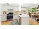 Bright kitchen with white cabinets, stainless steel appliances, and a sliding glass door to the patio at 7427 W Cedar Cir, Lakewood, CO 80226