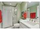 Clean bathroom features a white vanity, glass-enclosed shower, and fresh green walls at 3741 Harvard Pl, Broomfield, CO 80023