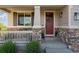 Inviting front porch with stone accents, decorative shutters, and a charming red front door at 3741 Harvard Pl, Broomfield, CO 80023