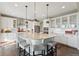 Bright kitchen boasts a large island with seating, sleek white cabinetry, and modern pendant lighting at 3741 Harvard Pl, Broomfield, CO 80023