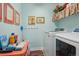 Bright laundry room with modern, white front-load washer and dryer and cheerful decor at 3741 Harvard Pl, Broomfield, CO 80023