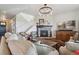 Inviting living room featuring a stone fireplace, stylish decor, and an open staircase to the upper level at 3741 Harvard Pl, Broomfield, CO 80023