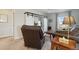Cozy living room features a leather chair, wood tables, and a white sliding barn door at 3741 Harvard Pl, Broomfield, CO 80023