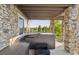 Outdoor patio features a modern hot tub, stone pillars, and serene green views at 3741 Harvard Pl, Broomfield, CO 80023