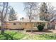Inviting backyard with a well-maintained lawn, mature trees, and a charming brick home at 6580 Independence Way, Arvada, CO 80004