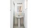 Bathroom with classic pedestal sink, modern fixtures, and bright natural light from a warm window at 6580 Independence Way, Arvada, CO 80004