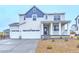 Charming two-story home featuring a three-car garage, front porch, and landscaped yard at 39857 Floyd St, Elizabeth, CO 80107