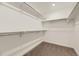 Bright walk-in closet with ample shelving and neutral carpeting; perfect for organizing clothes and accessories at 39857 Floyd St, Elizabeth, CO 80107