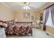 Comfortable bedroom featuring a floral patterned bed, ceiling fan, and bright natural lighting at 17038 Lamar Dr, Parker, CO 80134