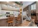 Well-lit kitchen with hardwood floors, counter seating, and white cabinets at 17038 Lamar Dr, Parker, CO 80134