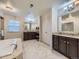 Luxurious bathroom featuring dual vanities, granite counters, and a separate tub at 1648 Exquisite St, Castle Rock, CO 80109