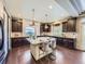 Modern kitchen featuring dark wood cabinets, granite countertops, and a large central island with bar stool seating at 1648 Exquisite St, Castle Rock, CO 80109