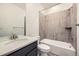 Modern bathroom featuring a tub with stylish wood-look tiling and vanity with a stone countertop at 615 Twilight St, Erie, CO 80516