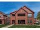 Condo building with brick facade, covered patio, and well-maintained lawn, showcasing its inviting curb appeal at 1379 Charles # 4, Longmont, CO 80503