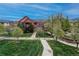 Attractive exterior view of brick townhomes with Tudor-style accents, surrounded by lush landscaping and walking paths at 1379 Charles # 4, Longmont, CO 80503