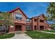 Charming condo building featuring Tudor style architecture with brick and decorative trim, lush lawn, and mature tree at 1379 Charles # 4, Longmont, CO 80503