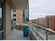 This private balcony features outdoor seating, glass railings, and stunning city views at 4200 W 17Th Ave # 323, Denver, CO 80204