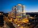 Stunning exterior view of a modern high-rise building with large windows and city lights at twilight at 4200 W 17Th Ave # 323, Denver, CO 80204