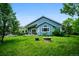 Spacious backyard featuring a fire pit, well-maintained green space, and a charming blue home at 19113 W 60Th Ln, Golden, CO 80403