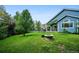 Lush backyard featuring a covered patio area and a charming stone fire pit, perfect for outdoor entertaining at 19113 W 60Th Ln, Golden, CO 80403