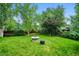Lush backyard featuring a circular fire pit, mature trees, and well-maintained green space at 19113 W 60Th Ln, Golden, CO 80403