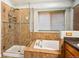 Bathroom featuring glass shower, soaking tub with tile surround, and natural light at 19113 W 60Th Ln, Golden, CO 80403