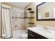 Well-lit bathroom showcases a tub with tiled walls, black shelving, and a vanity with a white countertop at 19113 W 60Th Ln, Golden, CO 80403