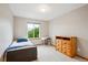 Bright bedroom featuring neutral walls, a large window with scenic views, and natural wood furniture at 19113 W 60Th Ln, Golden, CO 80403