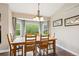 Bright dining room with a large window, wooden table, and elegant chandelier at 19113 W 60Th Ln, Golden, CO 80403