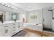 Modern bathroom with double vanity, a soaking tub, and a separate glass-enclosed shower at 17391 E Weaver Ave, Aurora, CO 80016