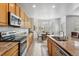 Eat-in kitchen with wood cabinets, stainless appliances, granite counters, and lots of natural light at 17391 E Weaver Ave, Aurora, CO 80016