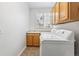 Bright laundry room includes newer washer and dryer, a window, and storage cabinets at 17391 E Weaver Ave, Aurora, CO 80016