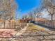Spacious fenced-in backyard with brick outbuilding, grassy area, and gravel at 4134 Bryant St, Denver, CO 80211