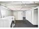 Unfinished basement area featuring laundry machines, exposed beams, and a sliding barn door at 4134 Bryant St, Denver, CO 80211