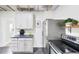 This well-lit kitchen features stainless steel appliances, white cabinetry, and grey flooring at 4134 Bryant St, Denver, CO 80211